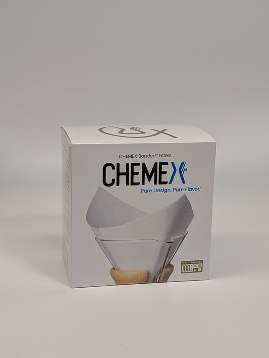 Pudełko białych, kwadratowych filtrów Chemex FS-100 na jasnym tle