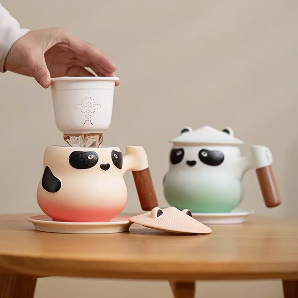 Wyjmowanie zaparzacza z koralowego kubka Panda obok miętowego wariantu
