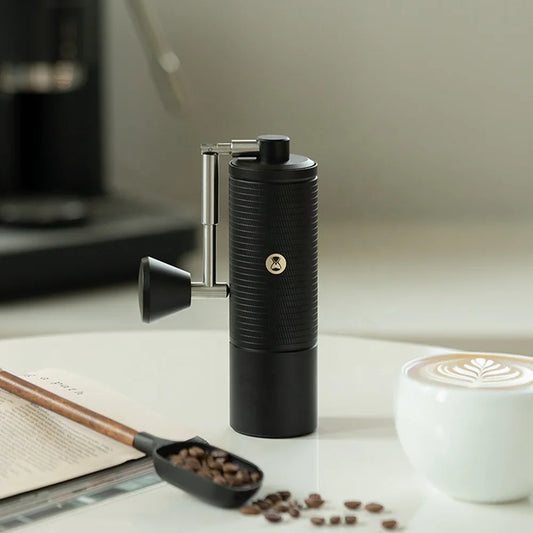 Timemore Chestnut C5 Esp Pro obok filiżanki kawy, książki i ziaren